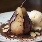 Poire Belle-Hélène nappée de chocolat chaud avec glace vanille et amandes grillées sur une assiette dans une cuisine maison.