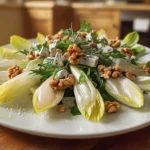 Salade d'endives, noix et roquefort présentée dans une cuisine de maison.