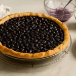 Tarte aux myrtilles maison sortie du four sur table de cuisine