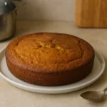 Photographie d’un gâteau au yaourt sans sucre fait maison posé sur un plan de travail dans une cuisine familiale.