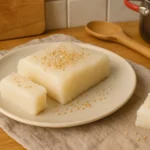 Gâteau de riz coréen (Tteok) maison, photographié dans une cuisine familiale avec des ustensiles en arrière-plan