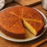 Photo d’un gâteau semoule marocain traditionnel, moelleux et doré, présenté dans une cuisine familiale.