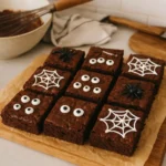 Brownies Halloween au chocolat faits maison, décorés avec des yeux en sucre et des toiles en chocolat blanc dans une cuisine familiale