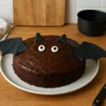 Gâteau chauve-souris d’Halloween au chocolat décoré avec pâte à sucre noire dans une cuisine familiale