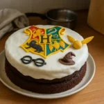 Gâteau Harry Potter fait maison décoré avec le blason de Poudlard et une Snitch dorée dans une cuisine familiale