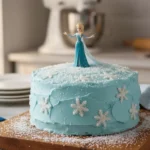 Gateau Reine des Neiges facile décoré avec glaçage bleu, flocons de neige en sucre et décoration Disney Elsa, parfait pour un anniversaire d’enfant.