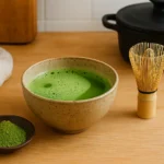 Photo d’un thé matcha maison crémeux, préparé avec un fouet en bambou et une poudre de matcha verte intense, présenté dans un bol traditionnel japonais.